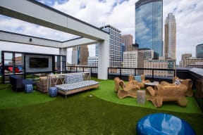 a roof top patio with furniture and a view of the city
