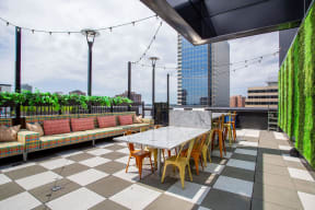 a rooftop patio with tables and chairs and a view of the city