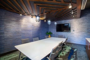 a conference room with a white table and a tv
