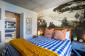 a bedroom with a bed and a mural on the wall