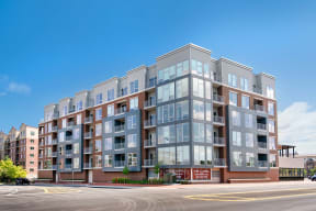 a large apartment building on a street with a blue sky in the background