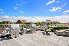 Studios in Mount Prospect, IL - 20 West - Outdoor Patio with Green Cushioned Seating Next to a Grilling Area