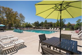 a pool with chairs and a table with an umbrella