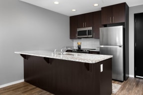 a kitchen with a granite counter top and a stainless steel refrigerator