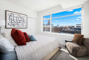 a bedroom with a bed and a large window