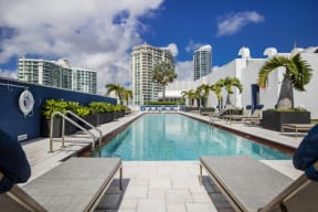 a swimming pool at a hotel with skyscrapers in the background