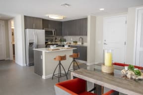 a kitchen and dining room with a table and chairs and a refrigerator