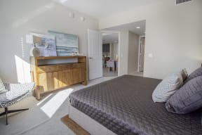 a bedroom with a bed and a dresser and a bathroom