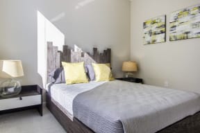 a bedroom with a bed and paintings on the wall