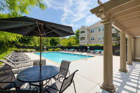 our apartments have a large pool and patio with chairs and umbrellas