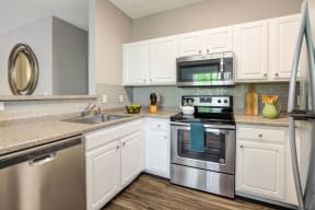 a kitchen with stainless steel appliances and white cabinets