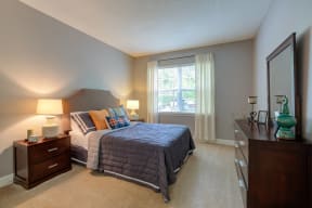 a bedroom with a bed and a dresser and a window