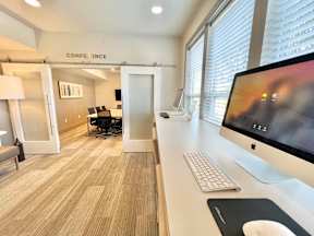 A conference room with a computer on the desk.