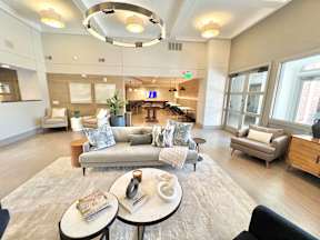 A spacious living room with a large grey sofa and a coffee table in the center.