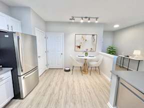 A kitchen with a black fridge and white cabinets.