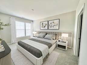 A modern bedroom with a large bed and a small nightstand.