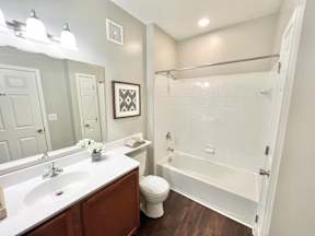 A bathroom with a white tub and a white toilet.