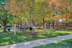 A park with a picnic table and a playground.