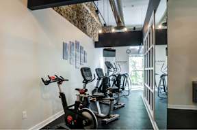 A gym with exercise bikes and a wall of pictures.