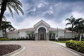 A large house with a grey roof and a driveway in front.