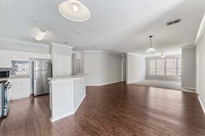 A kitchen with white cabinets and a refrigerator.