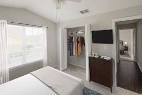 A bedroom with a bed, a wardrobe, and a TV.