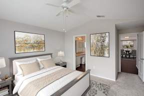 A bedroom with a large bed and a ceiling fan.