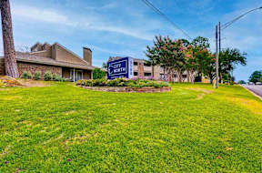 A grassy area in front of a building with a sign that says City North.