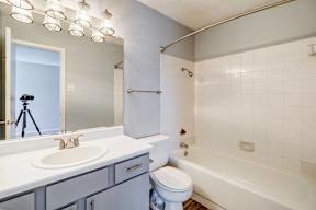 A bathroom with a white sink, toilet, and bathtub.