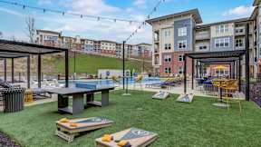 A backyard with a pool table and a ping pong table in The Artisan at Robinson's community