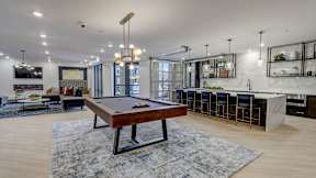 A pool table is in the middle of the community club room at The Artisan at Robinson