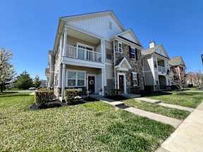 A two-story house with a balcony on the second floor.