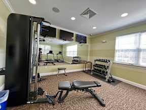 A home gym with a variety of equipment including a squat rack, bench, and dumbbells.
