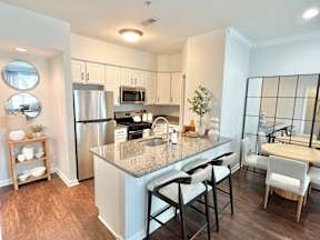 A kitchen with a granite countertop and stainless steel appliances.