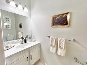 A bathroom with a white sink and towel rack.