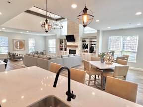 A modern kitchen with a large island and pendant lights.