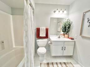 A white toilet with a red towel on top of it.