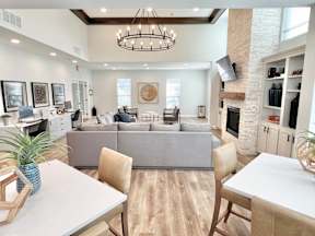 A modern living room with a grey sofa and a wooden dining table.