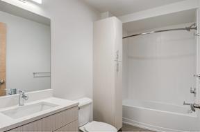 A white bathroom with a sink, toilet, and bathtub.