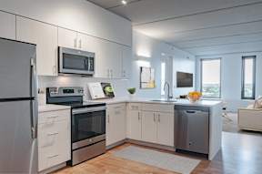 A modern kitchen with a refrigerator, oven, and microwave.