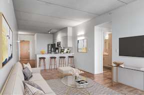 A modern living room with a grey sofa and a glass coffee table.