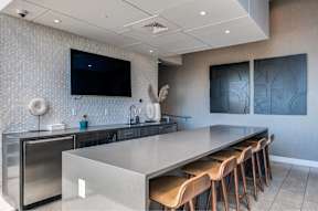 A modern kitchen with a long island and stainless steel appliances.