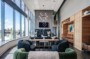 A modern living room with a large window and a TV on the wall.
