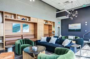 A modern living room with a blue couch and green chairs.