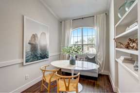 a dining room with a large window and a table with chairs