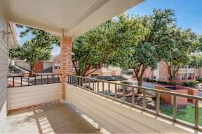 the view from the balcony of a residence with trees and a yard