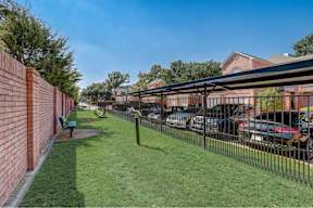 a fenced in yard with cars parked behind a fence