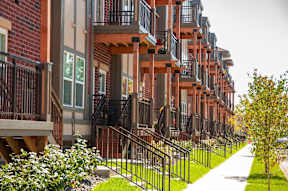 A long row of red brick apartment buildings with balconies.