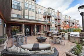 A patio area with tables and chairs in front of a building.