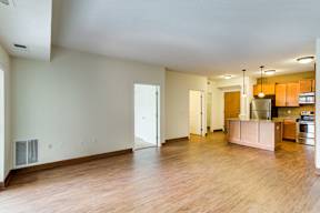 A kitchen area with a refrigerator, oven, and cabinets.